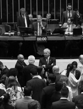 Sessão plenária e virtual para votar destaques à proposta de emenda Constituição (PEC) da reforma tributária. Na imagem, o presidente da Câmara dos Deputados, Arthur Lira, está sentado no centro da mesa do plenário da Câmara, enquanto outros integrantes da Casa conversam.